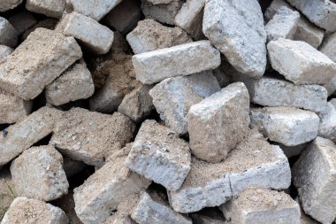 Pile of gray concrete bricks with rough surface texture for construction projects. clipart