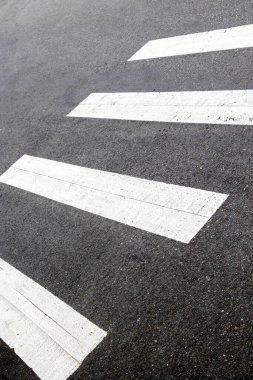 Asfalt sokak yüzeyinde beyaz çizgili şehir yaya geçidi.
