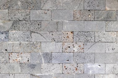 Textured gray stone wall with weathered surface and visible pores. clipart