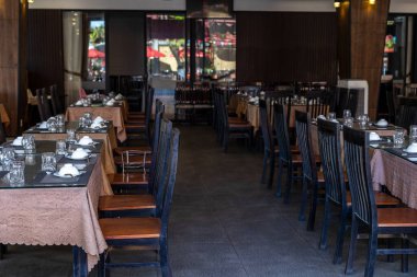 Boş lokanta yemek alanı. Masaları ve tahta sandalyeleri var..