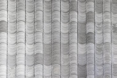 Tek renkli dalgalı çizgi deseni tekrarlanan siyah ve beyaz kavislerle optik illüzyon yaratıyor.