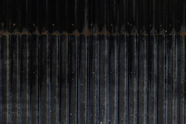 Paslı ve desenli yaşlanmış dikey metal paneller..