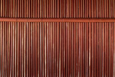 Dikey saplı ve yatay çapraz çubuklu doğal kırmızı bambu duvarı..