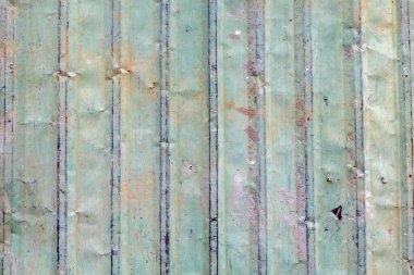 Yıpranmış dokusu ve dikey çizgileri olan taşralı yeşil metal panel.