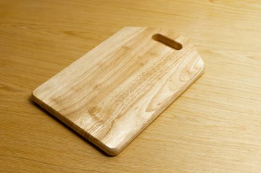 Hafif ahşap masa yüzeyinde tahta kesme tahtası.