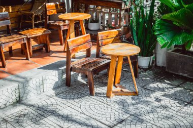 Kırsal ahşap dış mobilyalar, güneşli verandada yeşil yapraklı..