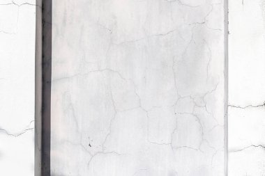 Dikey gölgeli ve yıpranmış yüzey detaylarıyla çatlamış beton duvar dokusu.