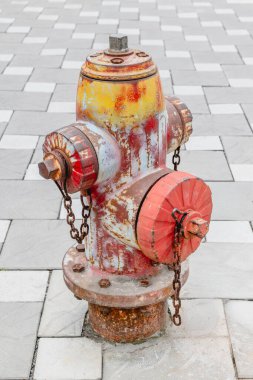 Damalı kaldırımda paslı yangın musluğu.