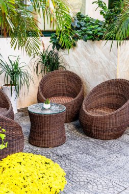 Hasır sandalyeleri ve yemyeşil yeşilliği olan rahat bir açık hava oturma alanı..