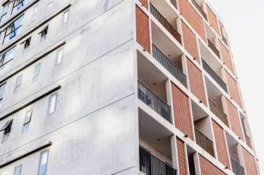 Tuğla ve beton cepheli modern şehir apartmanı.