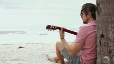 Sahil kenarındaki sakin gitar seansı: rahatlama, müzik ve okyanusun sakinliği