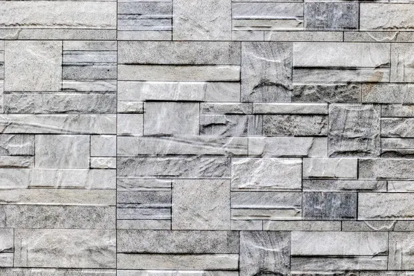 Değişik desenlere ve dikdörtgen düzende dokulara sahip doğal gri taş duvar dokusu.