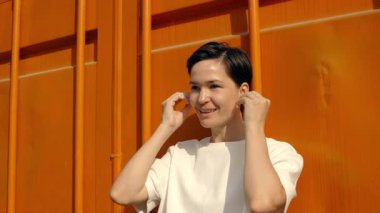 Neşeli ifade yolculuğu: canlı turuncu duvara karşı gülümseyen kişi duygusal geçişi yakalar