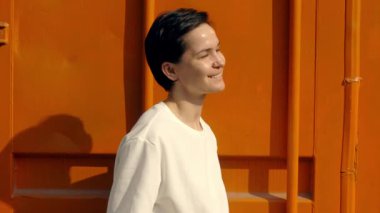 Beyaz bluzlu gülümseyen kadın parlak turuncu arka planda