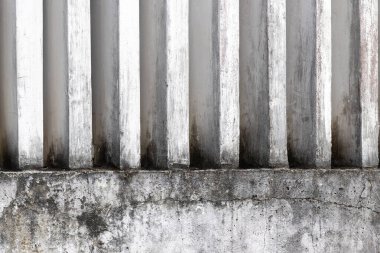 Dikey çizgileri ve yıpranmış dokusu olan eski beton bir duvar..