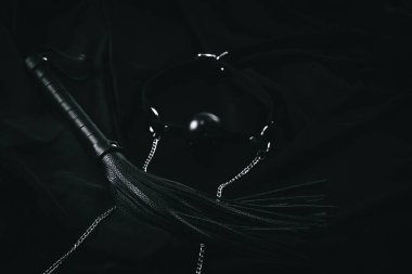 Siyah deri kamçı ve top koyu kumaşta..