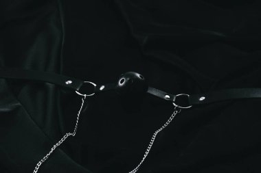 Siyah deri top, arka planda metal zincirler var..