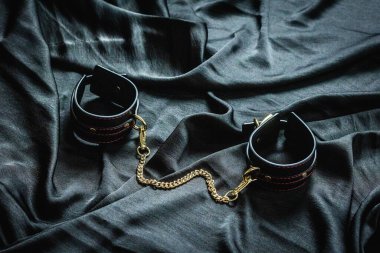 Deri bileklikler, arka planda altın zincir..