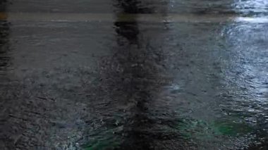 Şehir ortamında yansıtıcı nemli yüzeyde dans eden yağmur damlaları yüksek çözünürlükte yakalanır