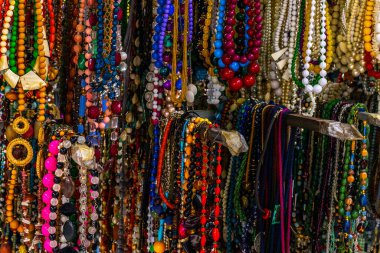 Vibrant assortment of colorful beaded necklaces in market display.
