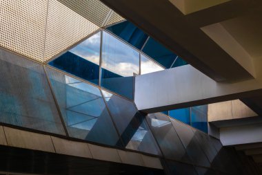 Cam ve çelik yansımalı modern geometrik mimari.