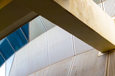 Delinmiş beyaz paneller ve geometrik desenler içeren modern mimari tasarım.