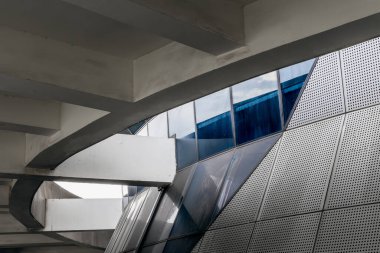 Geometrik desenleri ve cam yansımaları olan modern mimari tasarım.