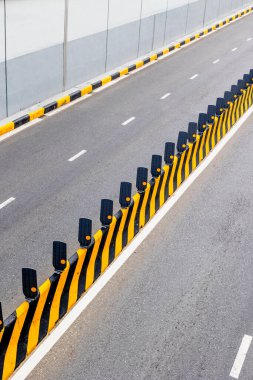 Sarı siyah bariyerler ve yansıtıcılarla boş şehir yolu.