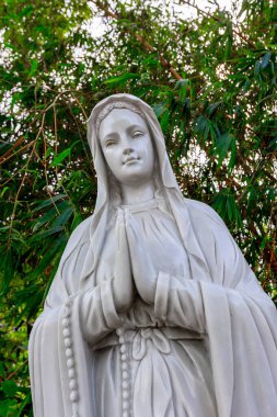 Bahçedeki dua eden kadının tespihli mermer heykeli..