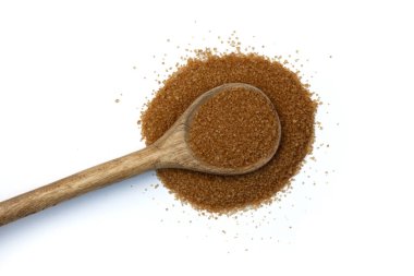 Beyaz arka planda kahverengi şekerli büyük kaşık, rafine edilmemiş doğal kamış şekeri, üst görünüm
