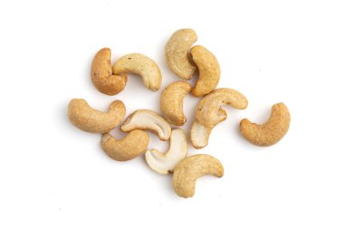 Beyaz arka plana saçılmış kaju fıstığı, izole edilmiş kavrulmuş fındık yığını, abur cubur konsepti, vegan yemeği.