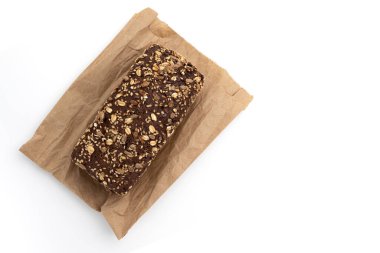 Beyaz arka planda izole edilmiş ambalaj kağıdının üzerine bir somun çavdar ekmeği, ev yapımı pişirme, taze tam tahıl.