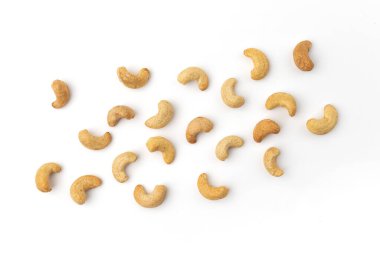 Beyaz arka plana saçılmış kaju fıstığı, izole edilmiş kavrulmuş fındık yığını, abur cubur konsepti, vegan yemeği.