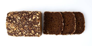 Beyaz arka planda çavdar ekmeği dilimleri, üst manzara, taze ev yapımı sağlıklı pişirme, tohumlu ekmek ve parçalanmış kırıntılar.