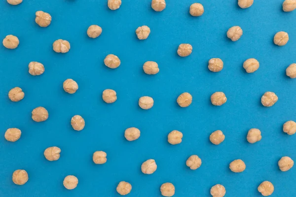 creative food layout, hazelnuts on blue background, top view, concept of food, healthy nutrition, hazelnut flat lay, nut pattern, organic healthy vegan snack
