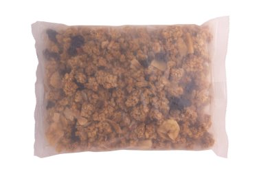 Şeffaf plastik poşette meyveler ve fındıklı granola beyaz arka planda izole edilmiş, pişmiş müsli karışımı, kahvaltı gevreği