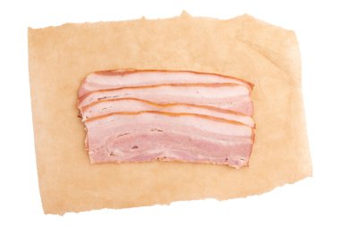 Makro, düz üst katmanı kapat pişmemiş domuz eti yağlı pastırma eti, kahverengi kağıtta besleyici yiyecekler, beyaz arka planda izole edilmiş parşömen kağıdında taze pastırma parçaları.