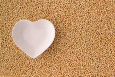 Kuru kuskus, sağlıklı kahvaltı konsepti, yemek malzemesi ve üst görünümün arka planında kalp şeklinde seramik kase.