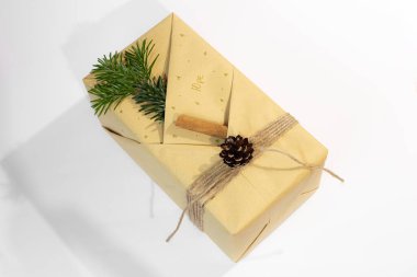 Noel, yeni yıl hediyeleri. Hediyeler. Güzel kutular, kurdeleler ve dekorasyonlar. Beyaz arka planda ağaç konileri. Kırmızı. El işi kağıdı. Tatil günü. Orijinal. Tarçın. Şeker. Paket Tasarımı