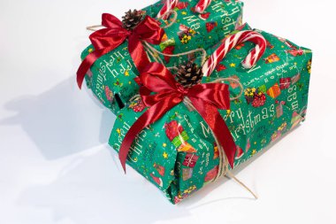 Noel, yeni yıl hediyeleri. Hediyeler. Güzel kutular, kurdeleler ve dekorasyonlar. Beyaz arka planda ağaç konileri. Kırmızı. El işi kağıdı. Tatil günü. Orijinal. Tarçın. Şeker. Paket Tasarımı