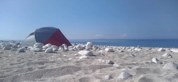 a beautiful shot of a beach with a tent and sea. Albania