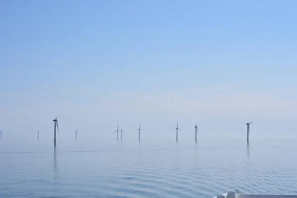 Mavi gökyüzü olan büyük bir rüzgar türbini.