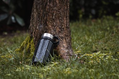 Ormandaki siyah bir termosun yakın plan çekimi. 