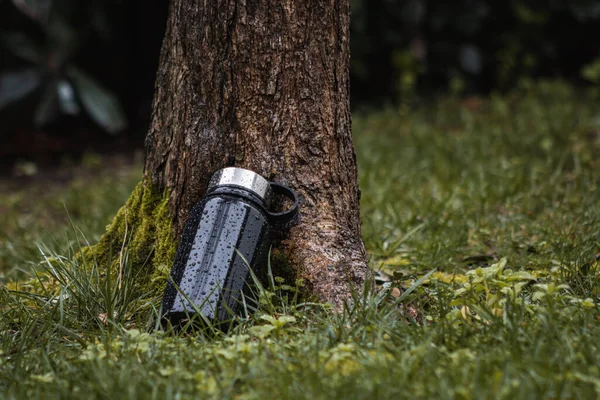 Ormandaki siyah bir termosun yakın plan çekimi. 