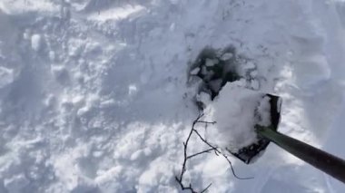 Pallas Yllastunturi Ulusal Parkı, Laponya, Finlandiya 'daki donmuş bir göldeki bir delikten su toplayan adam.