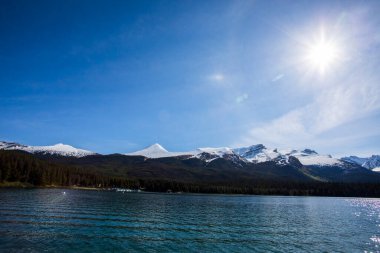 Yaz manzarası ve Maligne gölünde kayak yapan ve balık tutan insanlar, Kanada 'da Jasper Ulusal Parkı