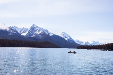 Yaz manzarası ve Maligne gölünde kayak yapan ve balık tutan insanlar, Kanada 'da Jasper Ulusal Parkı