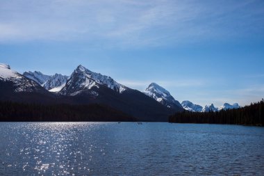 Yaz manzarası ve Maligne gölünde kayak yapan ve balık tutan insanlar, Kanada 'da Jasper Ulusal Parkı