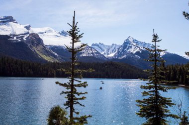 Yaz manzarası ve Maligne gölünde kayak yapan ve balık tutan insanlar, Kanada 'da Jasper Ulusal Parkı