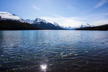 Yaz manzarası ve Maligne gölünde kayak yapan ve balık tutan insanlar, Kanada 'da Jasper Ulusal Parkı